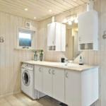 Badezimmer mit Waschmaschine, Spiegelschrank und Fenster.