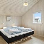 Schlafzimmer mit Bett, Nachttisch und Fenster.