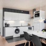 Kitchen with washing machine, dining area, and wooden wall