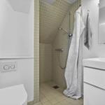 Badezimmer mit Dusche, Waschbecken und Toilette.