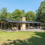Moderne Villa mit Terrasse, Grill und Blick auf den Wald.