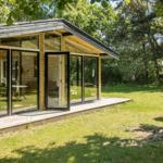Moderne Holzhütte mit großem Glasbereich im Grünen