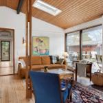 Wohnzimmer mit Kamin, Sofa und Glasfront zum Garten