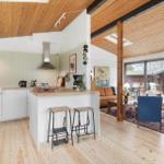 Küche mit Insel und Wohnzimmer mit Kamin und Holzboden