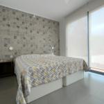 Schlafzimmer mit Bett, Tapete und großem Fenster.
