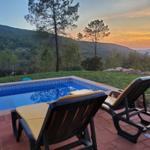 Pool mit Liegestühlen und Bergblick bei Sonnenuntergang.