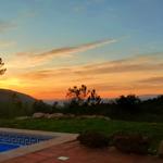 Pool mit Blick auf Sonnenuntergang über Hügeln und Bäumen