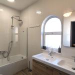 Badezimmer mit Dusche, Waschbecken und Holzboden