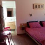 Schlafzimmer mit Bett, Wandbild und Sicht auf Badezimmer.