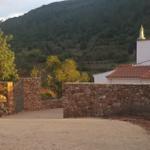 Eingangstor zu einer Villa mit Steinmauer und Berg im Hintergrund.