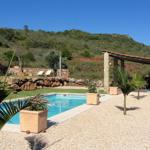 Pool mit Liegestühlen, Terrasse und Blick auf Hügel
