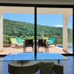 Terrasse mit Pool und Bergblick durch große Glastüren