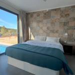 Schlafzimmer mit Blick auf Pool und Landschaft.