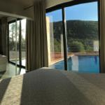 Schlafzimmer mit Blick auf Pool und Berglandschaft.