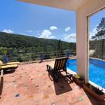 Terrasse mit Pool, Sonnenliegen und Bergblick.