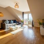 Wohnzimmer mit Sofa, Couchtisch und Blick auf Balkon