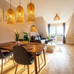 Wohn- und Essbereich mit Holzboden, Esstisch, Sofa und Fernseher.