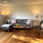 Living room with gray sofa, wooden floor, and floor lamp.