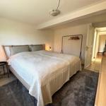 Bedroom with bed, clothing rack, and nightstand.