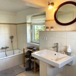 Bathroom with bathtub, sink, and wooden towel rack.