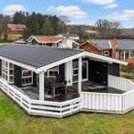 Schwarzes Haus mit weißer Veranda und Garten