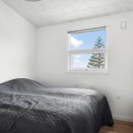 Schlafzimmer mit Bett, Fenster und Nachttisch