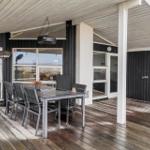 Terrasse mit Tisch und Stühlen unter Dach