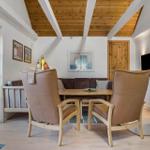 Wohnzimmer mit Holzdecke, Sitzgelegenheiten und Kaminofen.