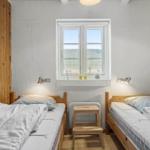 Zwei Schlafzimmer mit Holzbetten und Fenster zur Aussicht.