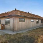 Holzhaus mit Dach aus Gras und mehreren Fenstern