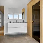 Badezimmer mit Waschbecken, Spiegel und Sauna
