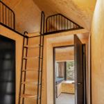 Holzvertäfelte Wohnung mit Doppelstockbett und Treppe.