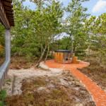 Haus mit Holzsauna auf Terrasse im Wald