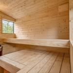 Sauna mit Holzbank, Heizung und Fenstern.
