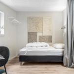Schlafzimmer mit Bett, Vorhängen und Wanddekoration.