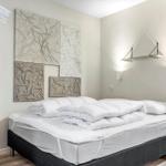 Schlafzimmer mit Bett, Wanddekoration und Wandlampe.