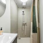 Badezimmer mit Dusche, Waschbecken und Spiegel