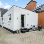 Moderne weiße Hütte mit Terrasse und Essbereich im Außenbereich.