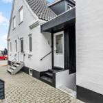 Weiße Fassade mit schwarzen Akzenten und Eingangstreppe