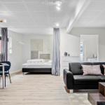 Schlafzimmer mit Bett, Wohnbereich mit Sofa und Couchtisch.
