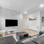 Wohnzimmer mit Sofa, Fernseher und Couchtisch.
