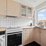 Küche mit Holzschränken, Spüle und Fensterblick