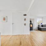 Wohnzimmer mit Holzboden, Sofa, Kamin und Wanddekoration.