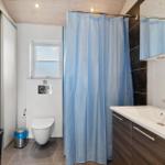 Badezimmer mit Dusche, Waschbecken und Toilette.