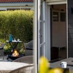 Terrasse mit Sitzgelegenheiten und Feuerkorb. Tisch mit Kanne und Tassen.