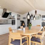 Küche mit Essbereich und Holztisch. Kamin und moderne Beleuchtung.