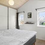 Schlafzimmer mit Bett, Fenstern und Schiebetüren.