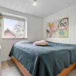 Bedroom with bed, window, and wall art.