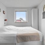 Bedroom with white bedding, window, and wall art.