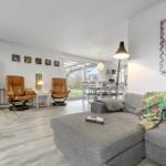 Living room with fireplace, leather chairs, and sofa. Access to terrace and dining area.